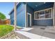 Side exterior view of the home featuring light blue siding, a covered patio, and a manicured lawn at 9422 E 58Th Pl, Denver, CO 80238
