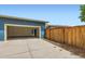 Exterior view of the home's garage with a concrete driveway and partial wooden fence at 9422 E 58Th Pl, Denver, CO 80238