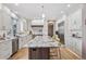 Modern kitchen features an oversized island, stainless steel appliances, white cabinets, and wood floors at 6971 S Netherland Way, Aurora, CO 80016