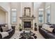 Bright living room with a fireplace, large windows, and leather couches at 6971 S Netherland Way, Aurora, CO 80016