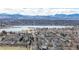 Overhead shot of a neighborhood with houses, trees, and a lake surrounded by a mountain range at 3142 W 20Th Ave, Denver, CO 80211