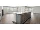 Open concept living room with hardwood floors, ample windows, and a modern island with stainless steel appliances at 3378 Backdrop Ct, Castle Rock, CO 80108