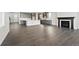 Open-concept living space with dark wood floors, flowing from a modern kitchen to a cozy fireplace area at 3378 Backdrop Ct, Castle Rock, CO 80108