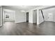 Spacious living area with gray wood floors, neutral walls, and a chandelier, leading to the foyer and other rooms at 3378 Backdrop Ct, Castle Rock, CO 80108