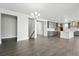Open-concept living space featuring gray wood floors, neutral walls, and kitchen area in the background at 3378 Backdrop Ct, Castle Rock, CO 80108