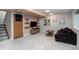 Finished basement area featuring a plush sofa, TV, and minimalist decor with soft, neutral tones at 6306 Xavier St, Arvada, CO 80003