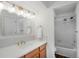 Well-lit bathroom with a single vanity, an illuminated mirror, and a shower-tub combination at 6306 Xavier St, Arvada, CO 80003