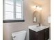 Charming bathroom featuring an arched mirror, modern lighting, and neutral color palette at 6306 Xavier St, Arvada, CO 80003