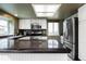 Well-lit kitchen featuring white cabinets, stainless steel appliances, and dark countertops at 6306 Xavier St, Arvada, CO 80003