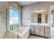 Bathroom featuring a luxurious bathtub and glass-enclosed shower at 8606 Hotchkiss St, Littleton, CO 80125