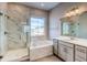Bathroom featuring a luxurious bathtub and glass-enclosed shower at 8606 Hotchkiss St, Littleton, CO 80125