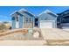 Attractive blue home with modern architectural design elements, an attached garage, and landscaped front yard at 8606 Hotchkiss St, Littleton, CO 80125