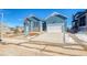 Charming blue home with a two-car garage, landscaped front yard, and a welcoming entrance on a sunny day at 8606 Hotchkiss St, Littleton, CO 80125