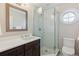 Bathroom features a sleek glass shower, dark wood vanity, and updated finishes at 115 S Glencoe, Denver, CO 80246