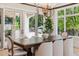 Formal dining room with a modern chandelier and views of the outdoor patio through large windows at 115 S Glencoe, Denver, CO 80246