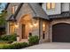 Close-up of a stone accented entryway with beautiful stonework, outdoor lighting, and manicured landscaping at 115 S Glencoe, Denver, CO 80246