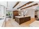 Spacious kitchen with a large center island, wood beams, and modern lighting fixtures at 115 S Glencoe, Denver, CO 80246