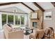 Cozy living room with vaulted ceilings, a stone fireplace, hardwood floors, and sliding glass doors to the backyard at 115 S Glencoe, Denver, CO 80246