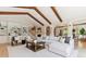 Bright living room with vaulted ceiling, exposed wood beams, built-in shelving, and a comfortable white sectional sofa at 115 S Glencoe, Denver, CO 80246