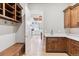 Well-organized mud room with custom wood cabinetry, white countertops, and open doorway to the adjacent white kitchen at 115 S Glencoe, Denver, CO 80246
