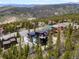 Aerial view showcasing the home nestled amongst trees with mountain views beyond the neighborhood at 436 N Fuller Placer Rd, Breckenridge, CO 80424