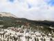 Extensive aerial view showcases a mountain community nestled among snow-covered evergreens and snow capped mountains at 436 N Fuller Placer Rd, Breckenridge, CO 80424