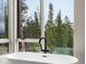 Close up of a bathtub next to a picture window with views of the forest outside at 436 N Fuller Placer Rd, Breckenridge, CO 80424