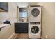 Functional laundry room with stacked washer and dryer, dark cabinets, and a sink with natural light at 436 N Fuller Placer Rd, Breckenridge, CO 80424
