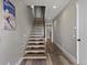 Modern staircase features floating wood steps, a sleek black handrail, and natural light coming from the hallway at 436 N Fuller Placer Rd, Breckenridge, CO 80424