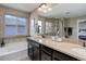 Primary bathroom with double vanity, granite counters, soaking tub, and glass shower enclosure at 10167 Nadine Ave, Parker, CO 80134