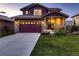 Charming two-story home featuring a well-manicured lawn, stone accents, and a spacious driveway leading to a two-car garage at 10167 Nadine Ave, Parker, CO 80134
