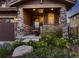 Inviting front porch adorned with stone pillars, a cozy seating area, and lush landscaping at 10167 Nadine Ave, Parker, CO 80134