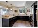 Bright kitchen features dark cabinetry, granite countertops, and hardwood floors at 10167 Nadine Ave, Parker, CO 80134