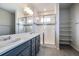 Modern bathroom features walk-in shower, dual sink vanity with quartz countertop, and built in shelving at 8609 Cheraw St, Littleton, CO 80125