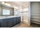 Bathroom with dual sinks, quartz countertop, walk-in shower, and decorative tile stripe at 8609 Cheraw St, Littleton, CO 80125
