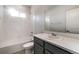 Bright bathroom featuring a white tiled shower-tub and single sink vanity with gray cabinets at 8609 Cheraw St, Littleton, CO 80125