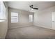 Bedroom with neutral carpet, ceiling fan, bright windows, and white trim at 8609 Cheraw St, Littleton, CO 80125