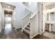 Bright hallway featuring hardwood floors, a staircase with white railings, and a glimpse of a bathroom at 8609 Cheraw St, Littleton, CO 80125