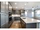 Modern kitchen features gray cabinets, stainless steel appliances, and a large island with pendant lighting at 8609 Cheraw St, Littleton, CO 80125