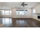 Open-concept living room with hardwood floors, large windows, and a modern ceiling fan at 8609 Cheraw St, Littleton, CO 80125