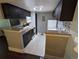 Modern kitchen with dark cabinetry, granite countertops, stainless steel appliances, and white tile floors at 1863 S Pitkin Cir # B, Aurora, CO 80017