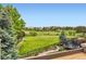 Backyard view featuring an expansive green space, trampoline, and neighborhood homes in the distance at 989 Graland Pl, Highlands Ranch, CO 80126