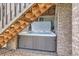Private outdoor hot tub offers a relaxing retreat, tucked under the deck stairs surrounded by stone accents at 989 Graland Pl, Highlands Ranch, CO 80126