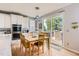 Cozy kitchen area featuring a wooden dining table with views through sliding glass doors to the brick patio at 989 Graland Pl, Highlands Ranch, CO 80126