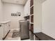 Functional laundry room with gray washer and dryer, folding counter, wooden floors, cabinets and stylish storage solutions at 989 Graland Pl, Highlands Ranch, CO 80126