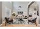 Elegant living room boasting tall ceilings, a modern chandelier, large windows, and a cozy seating area at 989 Graland Pl, Highlands Ranch, CO 80126