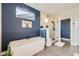 Relaxing bathroom featuring a freestanding tub, glass shower, and stylish blue accent wall at 2840 E 102Nd Pl, Thornton, CO 80229