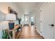 Inviting entryway with wood floors, a console table, and a view into a bright, modern office space at 2840 E 102Nd Pl, Thornton, CO 80229