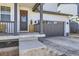 Close-up of the front entrance, featuring a gray front door with a decorative wreath and a covered porch at 2840 E 102Nd Pl, Thornton, CO 80229