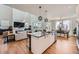 Open-concept living area featuring a kitchen island, dining area, and comfortable living space with a large television at 2840 E 102Nd Pl, Thornton, CO 80229